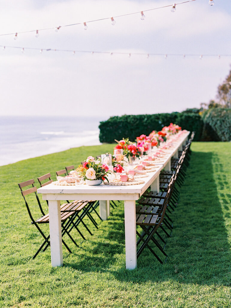 Wedding reception table overlooking the ocean with pink florals in San Diego